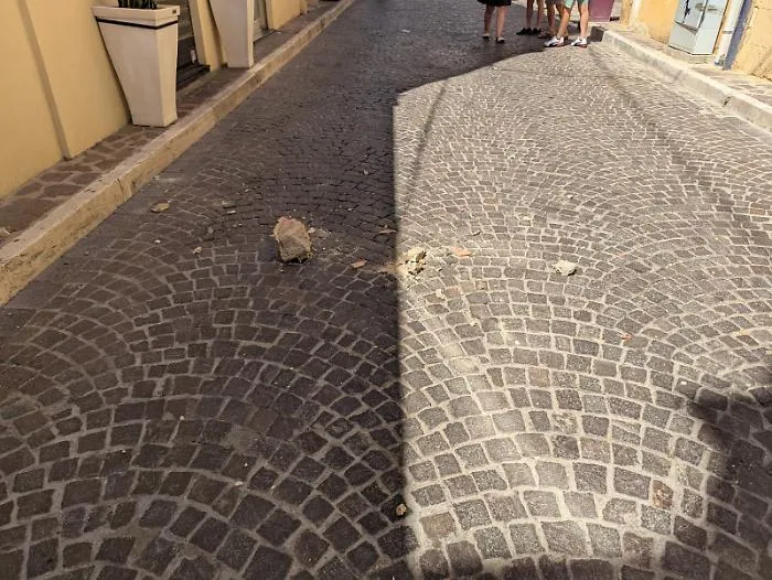Crolla un cornicione in via Atenea: passanti sfiorati dai calcinacci, sfiorata la tragedia